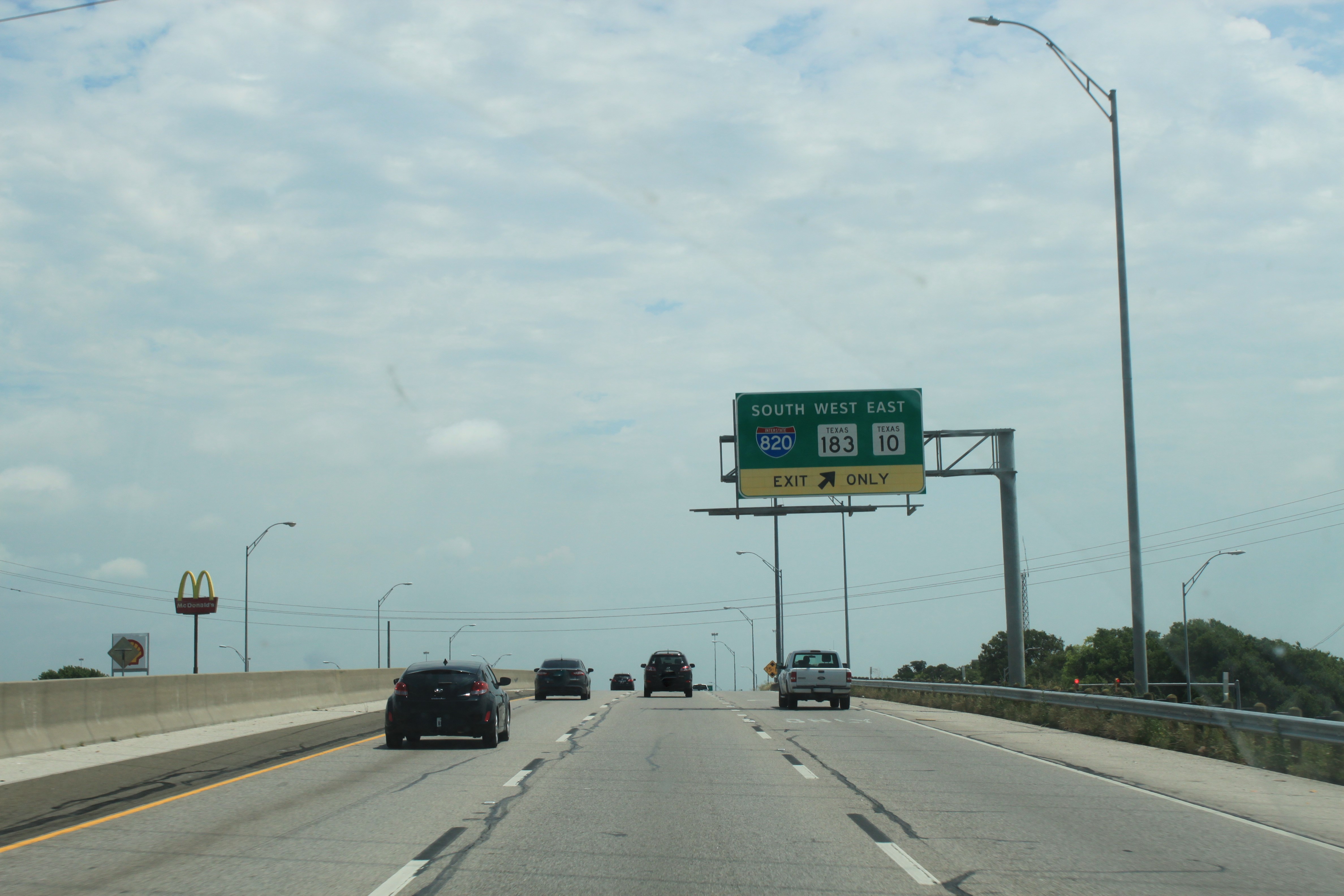 SH 121 northbound approaching I-820 at Handley Ederville Rd. Large overhead sign for southbound I-820, westbound SH 183, and eastbound SH 10 seen in mid-ground.