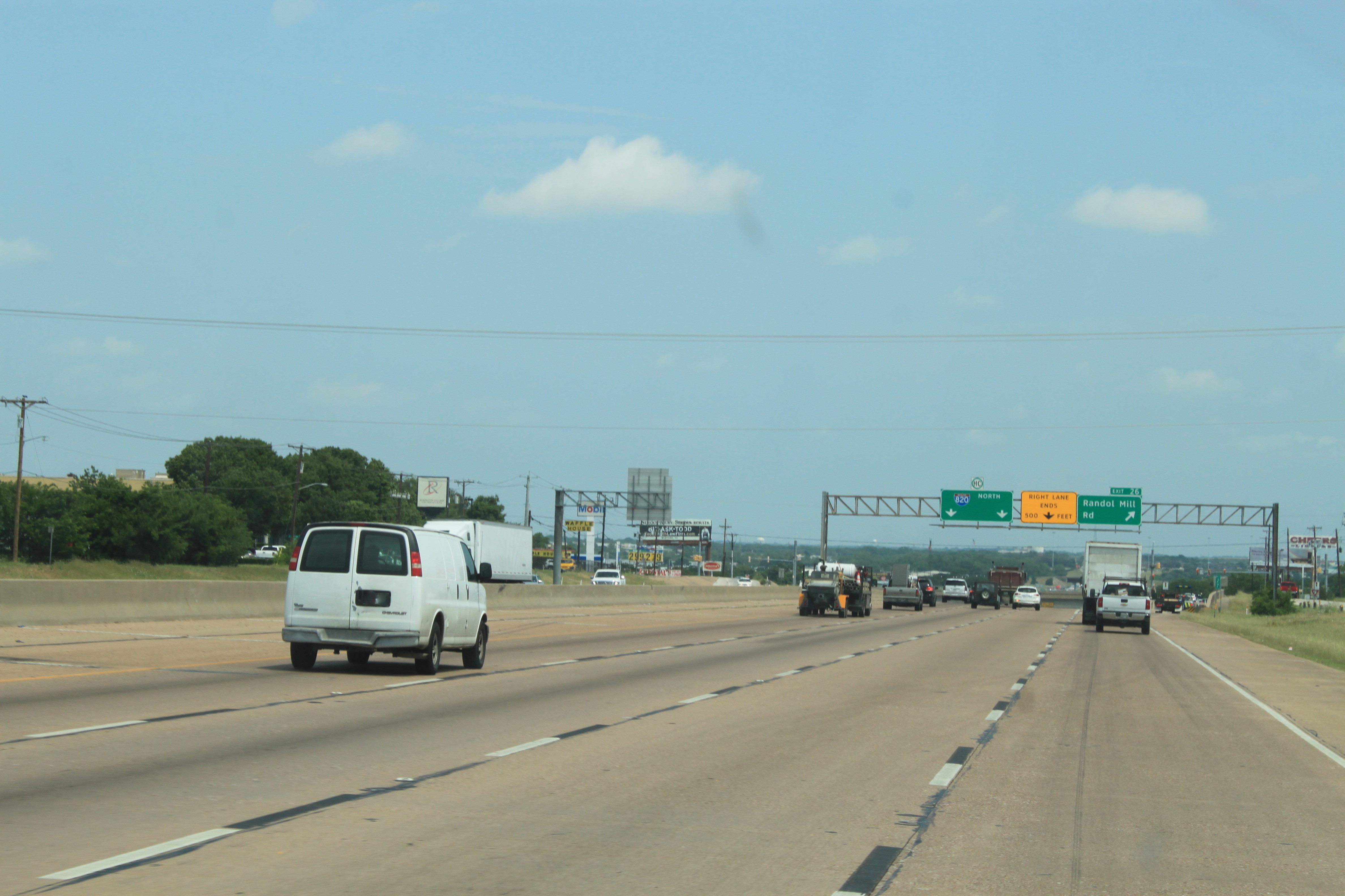 I-820 northbound approaching Randol Mill Rd. Large overhead sign in background showing exit to Randol Mill Rd, lane ending, and two through lanes for I-820.