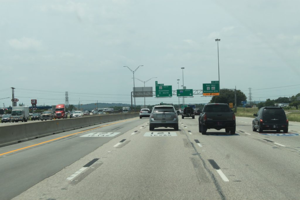 I-820 southbound approaching the SH 121 split. Pavement markings showing lanes for SH 121 and I-820.