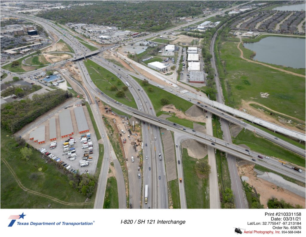 SH 121 looking northeast at I-820 interchange. Construction focus on new bridge structure in northwest quadrant.