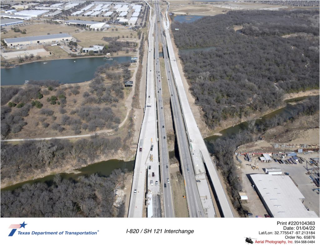 I-820 looking north over Trinity River. Construction of new pavement and structures on outsides of highway are shown.